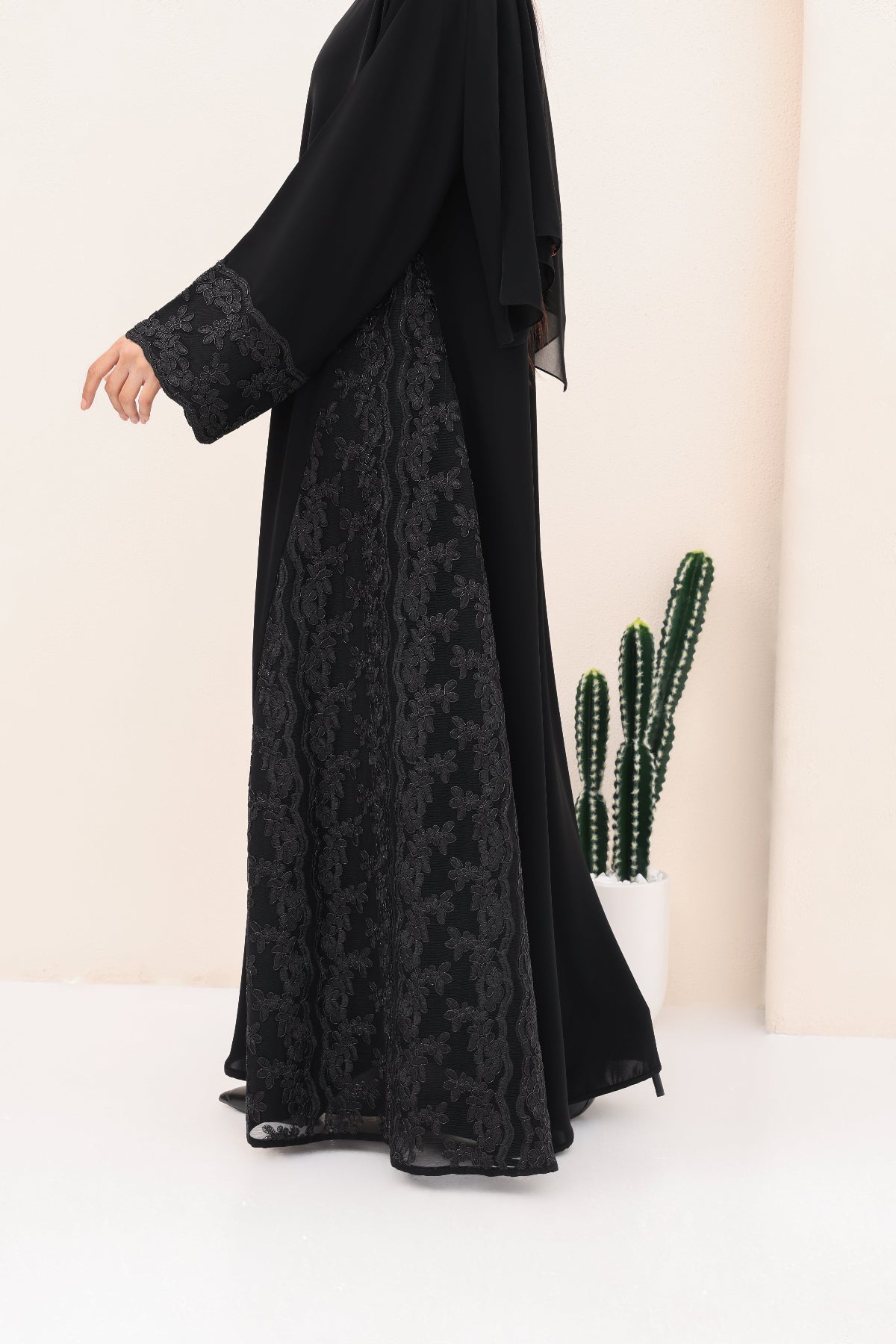 Black abaya with lace details on a white background