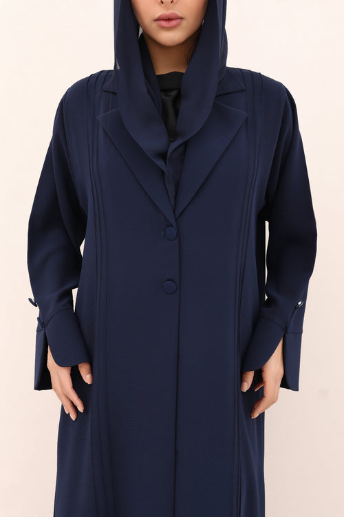 Navy blue hooded coat worn by a person on a beige background