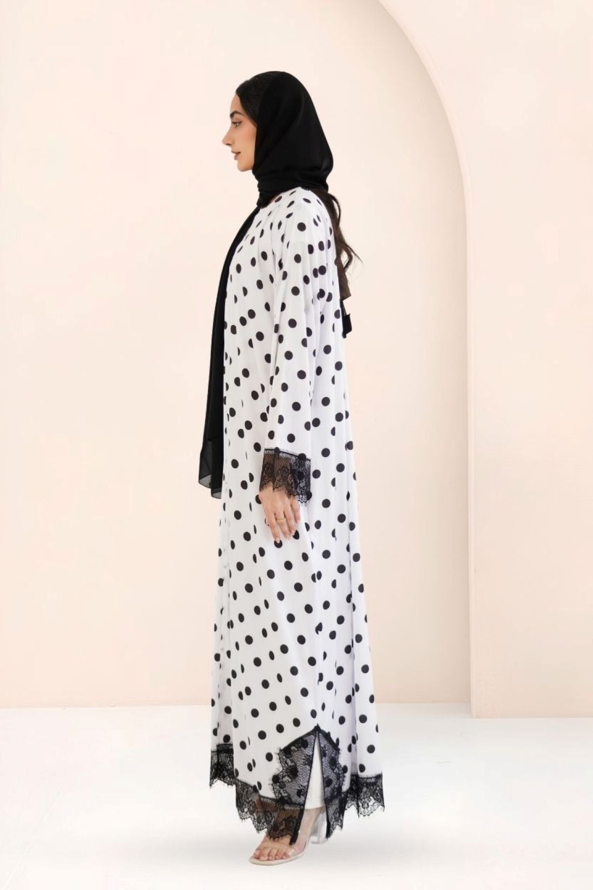Side view of A-line polka dot silk abaya showing straight sleeves and drape