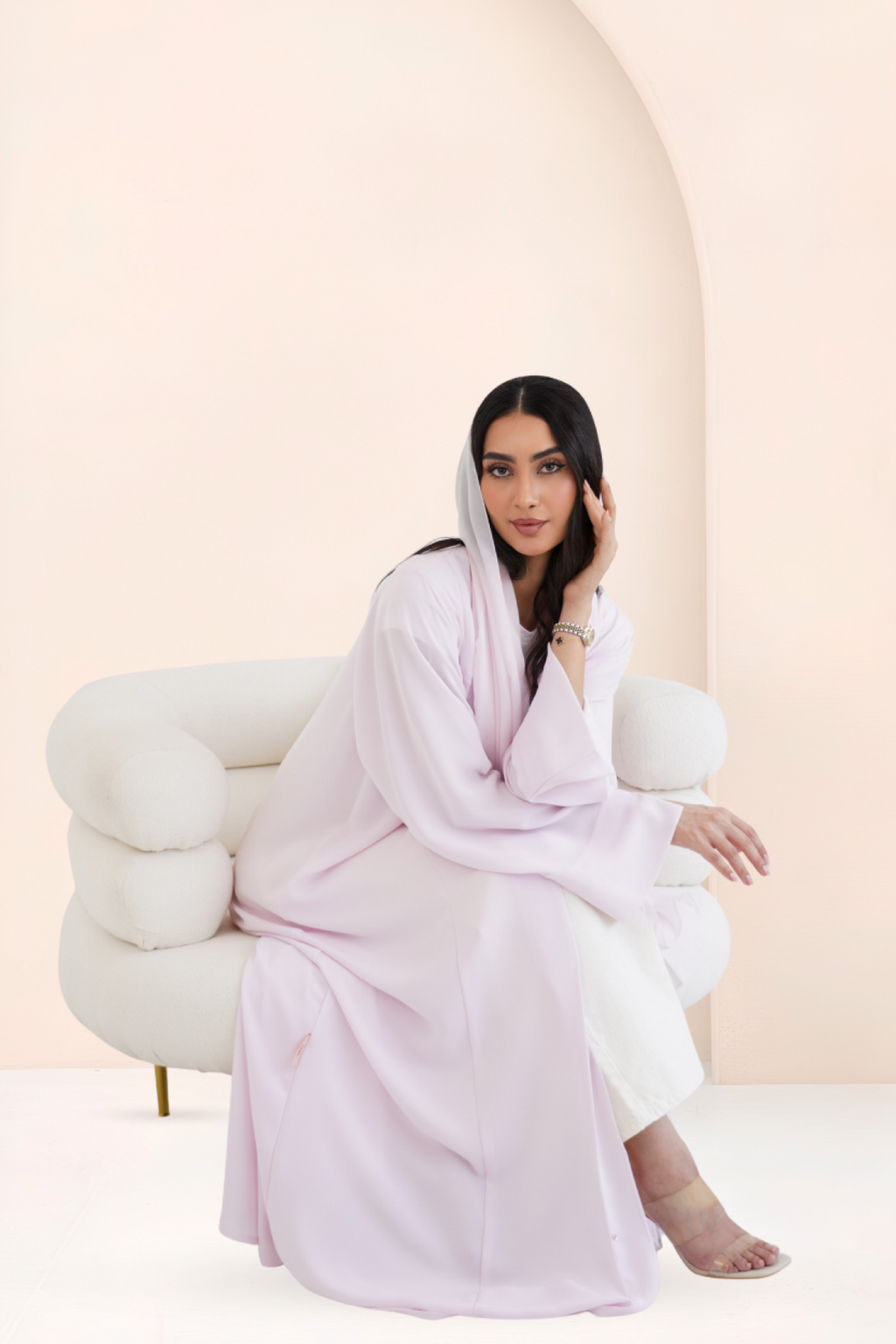 Model seated wearing Riwa Rose Latte abaya set with straight sleeves
