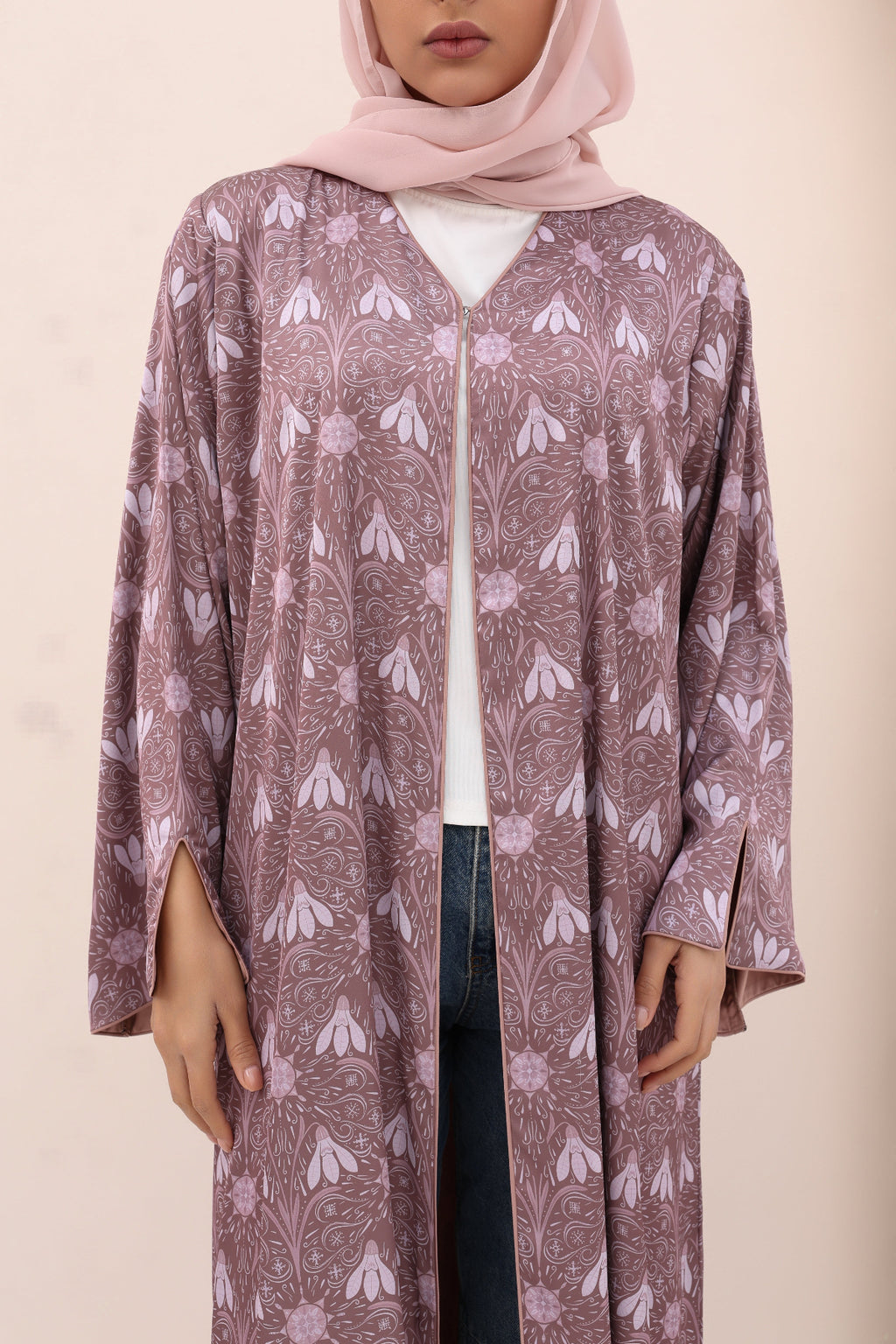 Person wearing a patterned long-sleeve top with a plain background