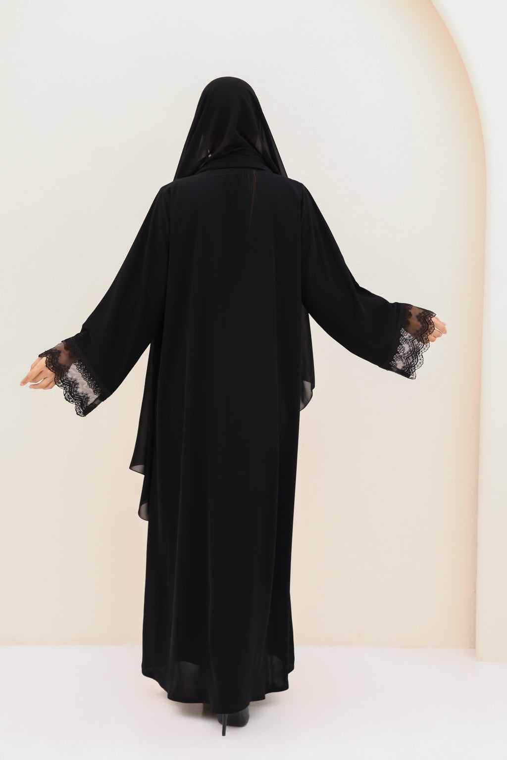 Black abaya with floral cuffs on sleeves against a white background