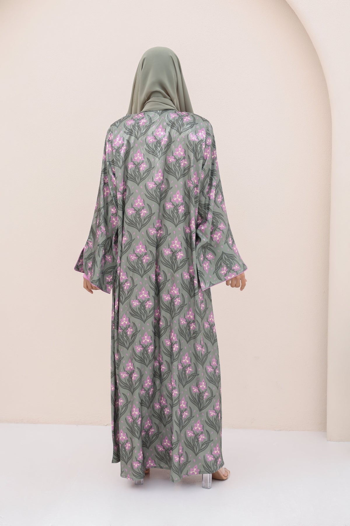 Woman wearing a floral abaya in a neutral setting